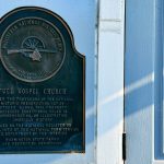 A bronze plaque on a white door marks the Full Gospel Church in Asotin, WA, as a registered National Historic Place, noting its historical value and registration on January 15, 1979.